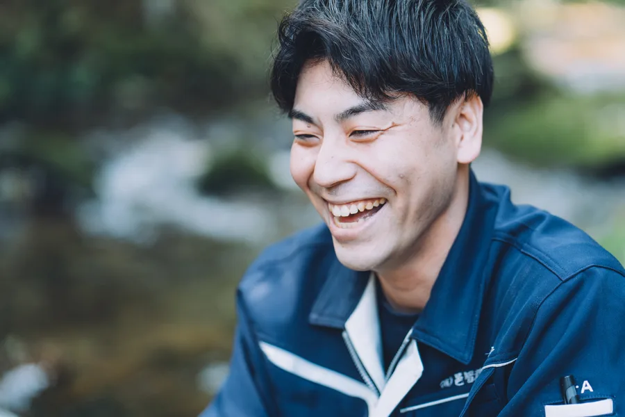 川辺で笑顔を見せるスタッフ