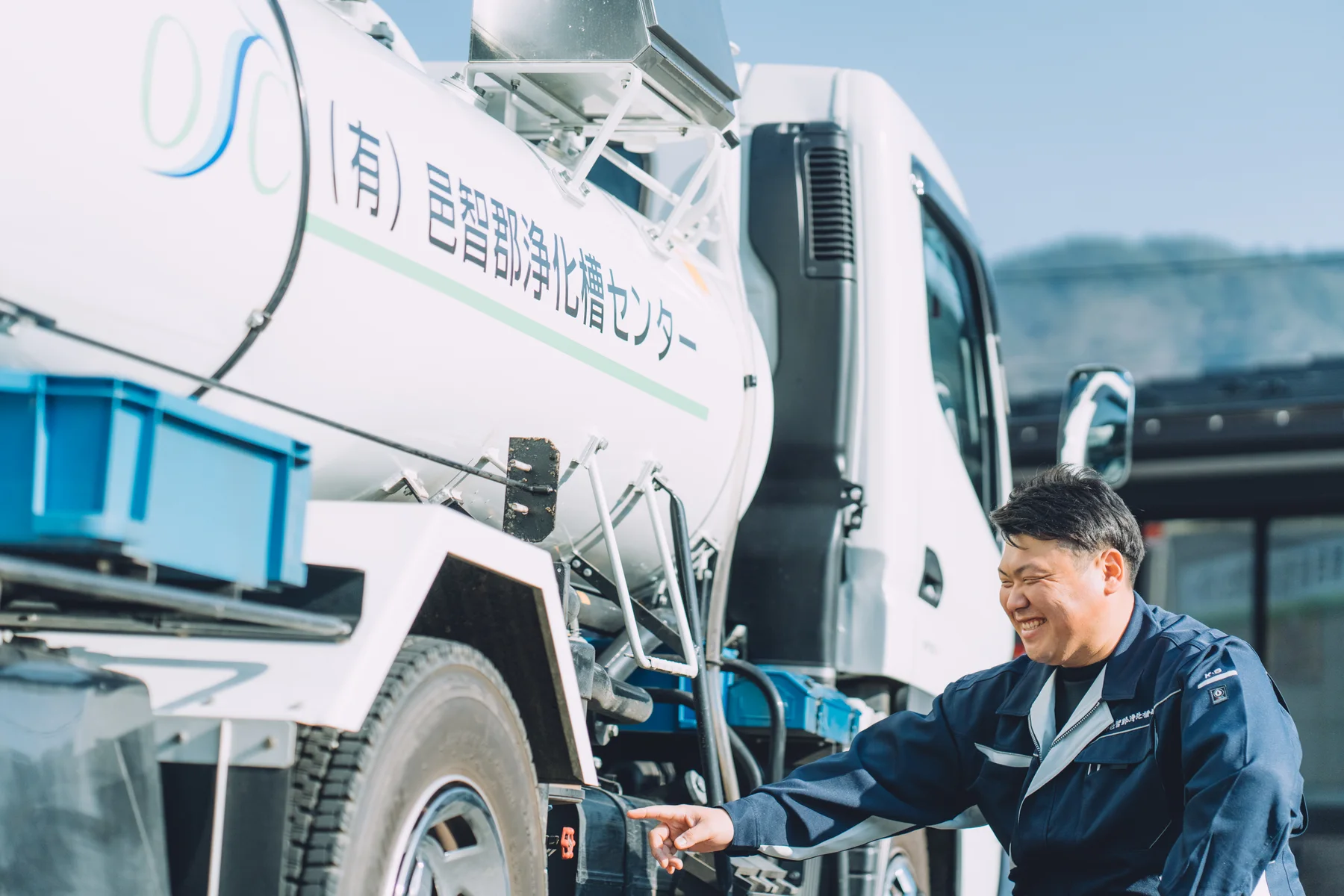 車両を確認する作業着姿のスタッフ